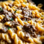 Creamy beef pasta dish served in a bowl with fresh herbs and cheese