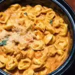 CrockPot Chicken Tortellini dish served with fresh herbs