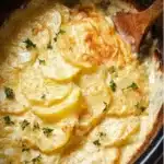 Creamy and cheesy crockpot scalloped potatoes in a dish