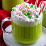 Delicious Grinch Hot Chocolate topped with whipped cream and festive decorations