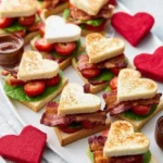Heart-shaped BLT bites on a plate, perfect for Valentine's Day snacks.