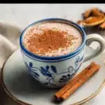 A rich bowl of champurrado, a Mexican chocolate drink, topped with cinnamon.