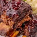 Delicious crockpot BBQ beef ribs with a sticky glaze and garnished with herbs