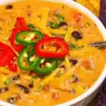 Bowl of delicious Crockpot Nacho Soup topped with cheese and jalapeños.