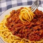 Crockpot spaghetti meat sauce served in a bowl with fresh herbs