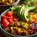 High-protein cheeseburger bowl with beef, lettuce, and toppings in a bowl