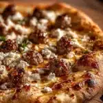 Sausage Feta Honey Pizza topped with sausage, feta cheese, and honey drizzled on a baked crust