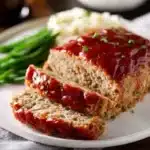 Delicious homemade turkey meatloaf served with vegetables and sauce