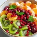Winter fruit salad with poppy seed dressing and fresh mint on a serving plate