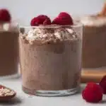 A bowl of blended chocolate overnight oats topped with fresh fruit and nuts.