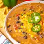 Crockpot Nacho Beef Soup ready to serve in a bowl, garnished with cheese and cilantro.
