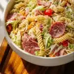 A colorful bowl of Italian Grinder Pasta Salad with vibrant vegetables and herbs.