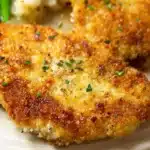 Deliciously crispy Parmesan Crusted Chicken served with herbs and vegetables