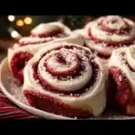 Delicious red velvet cinnamon rolls topped with cream cheese frosting for Christmas