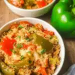 Delicious stuffed pepper casserole topped with cheese and fresh herbs