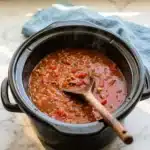 Bowl of Slow Cooker Stuffed Pepper Soup garnished with fresh herbs